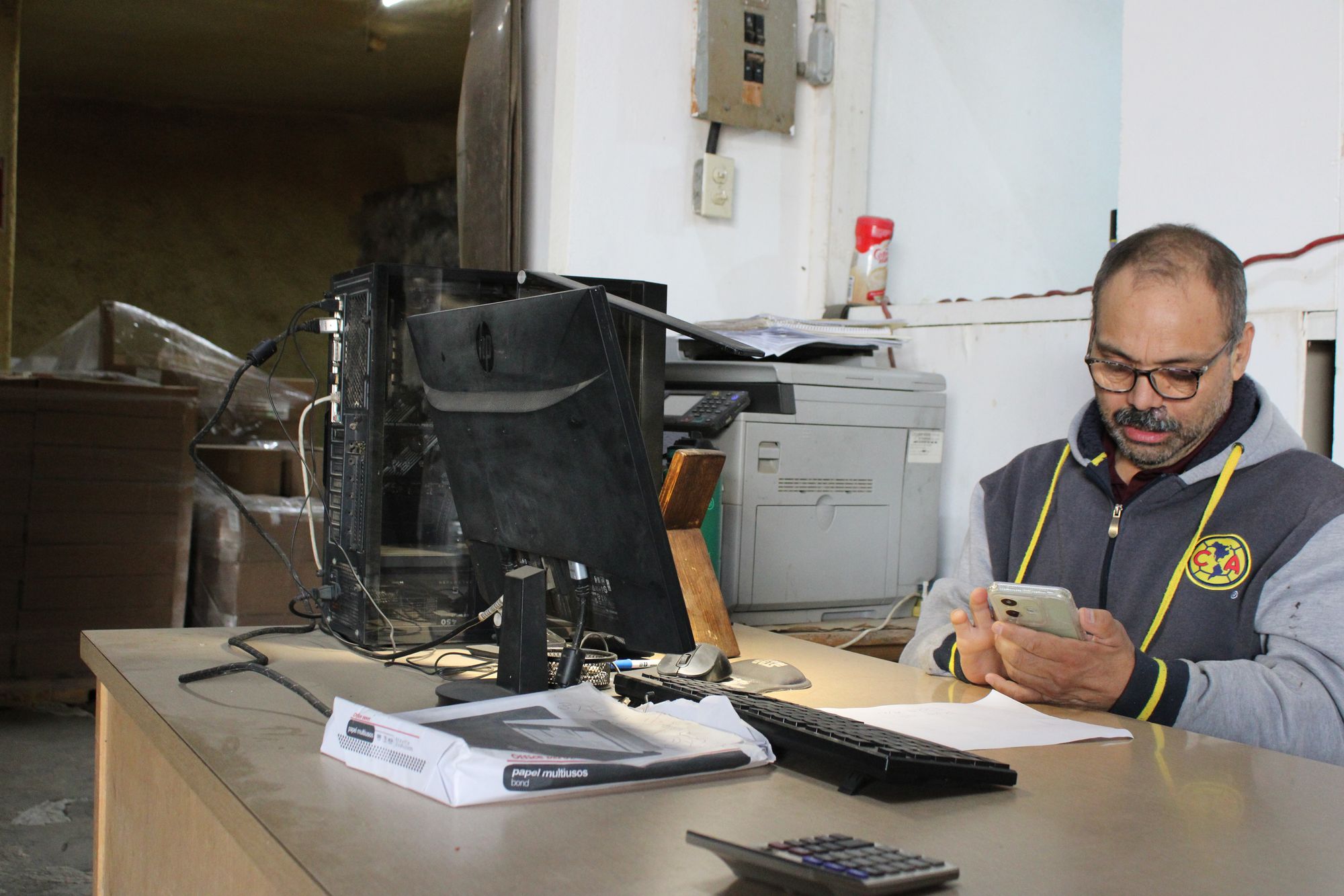 A farm worker at a desk in the packing office