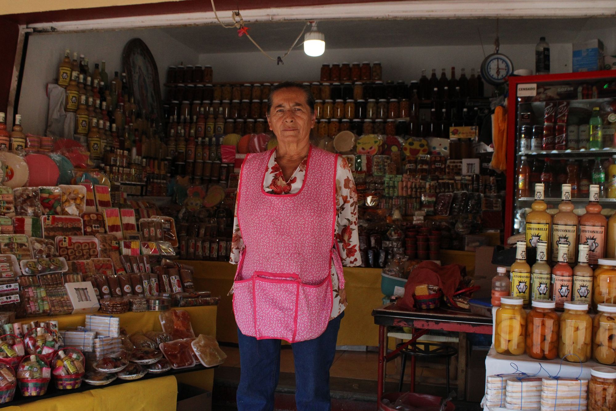Señora Membrillo standing in her candy shop